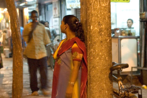 Borderless Captivity, Woman solicits customer in red light district, Mumbai, Ind