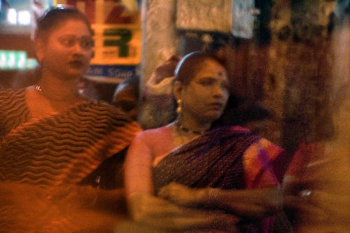 Borderless Captivity, Woman in red light district awaiting customers, Mumbai, In