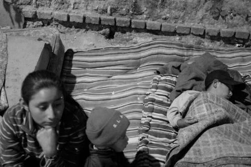 A girl with younger children on a mattress in the streets of Guatemala City amidst homeless adults. They can find a safe haven at Casa Alianza