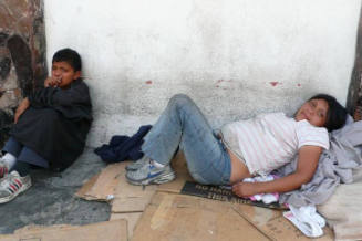 Young pregnant woman lies against cardboard on the street next to a boy that is inhaling. This is commonly seen amongst the adolescents who are later helped by CASA Alianza. Guatemala City